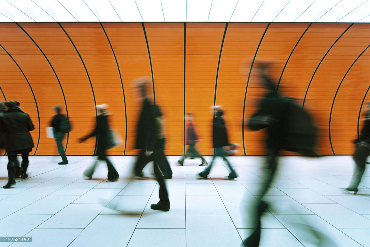 People walking past orange background