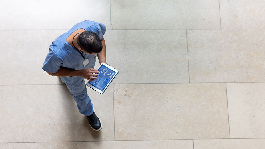 A nurse walking with a tablet